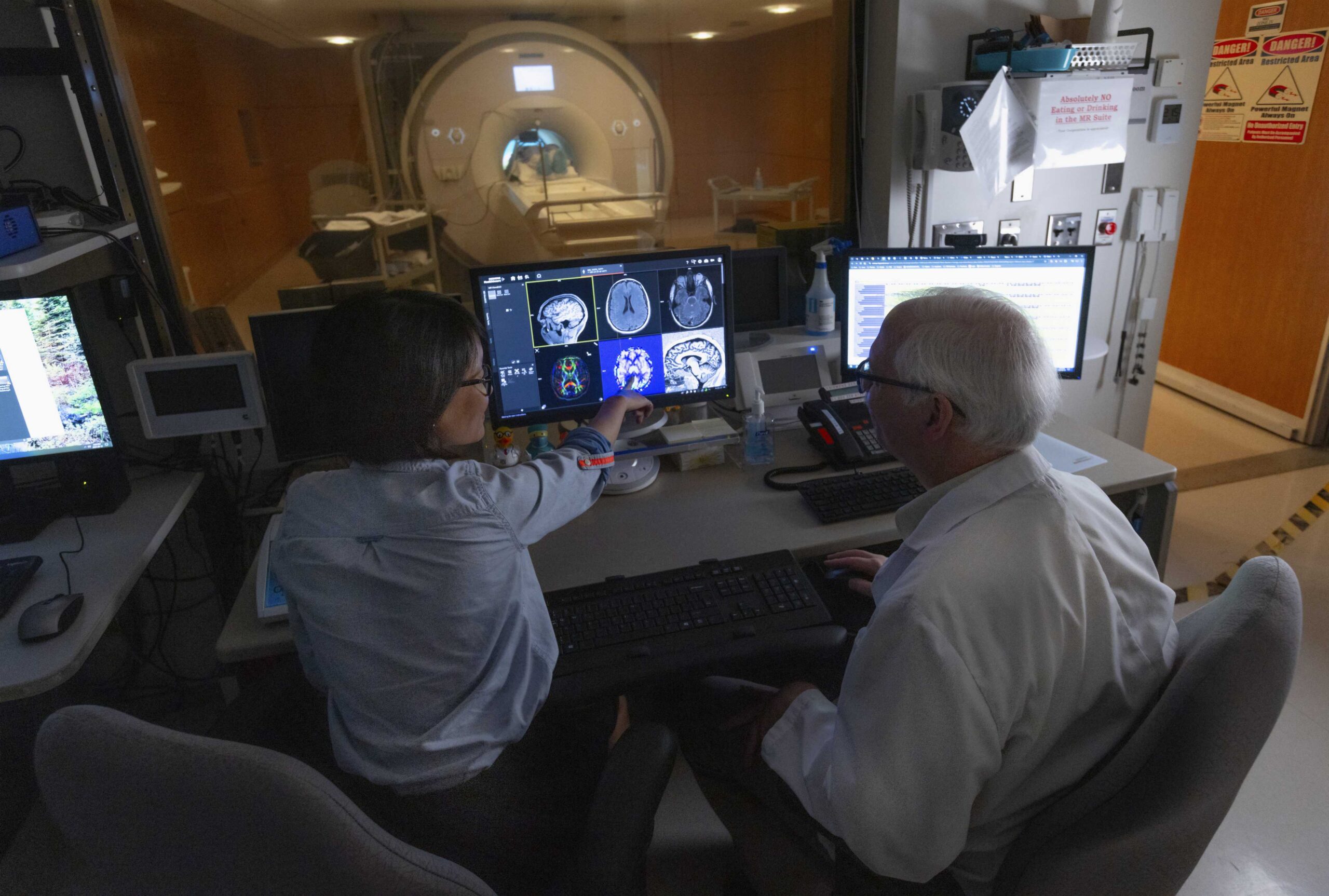 Physicians and researchers reviewing data on a computer screen
