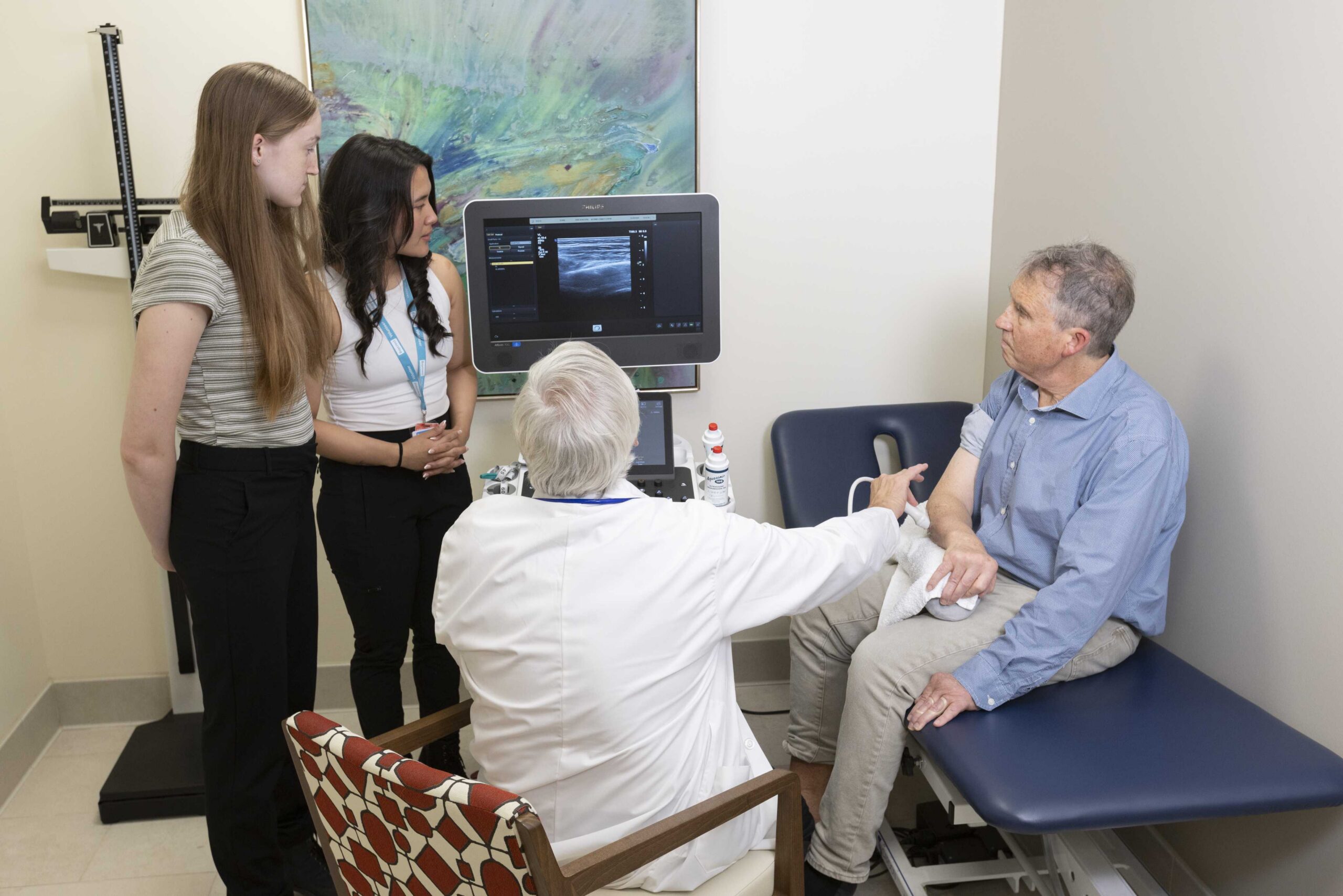 Researcher and students analyzing a client's arm